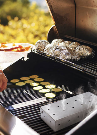 Grilling scene with smoker box being used. potatoes and flatbreads on a barbecue grill outdoors.